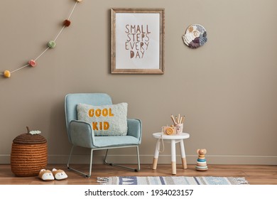Cozy interior of child room with mint armchair, brown mock up poster frame, toys, teddy bear, plush animal, decoration and hanging cotton colorful balls. Beige wall. Warm kid space. Template.