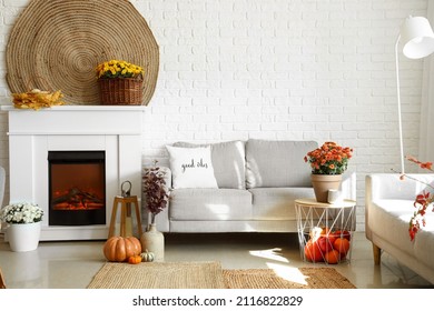 Cozy Interior Of Living Room With Fireplace, Sofa And Autumn Decor