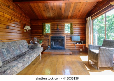 Cozy interior of a rustic log cabin with a fireplace.
