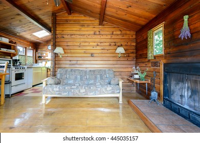 Cozy Interior Of A Rustic Log Cabin With A Kitchen And Fireplace.