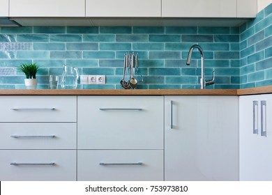 A Cozy Interior Of A White Kitchen With A Blue Tile