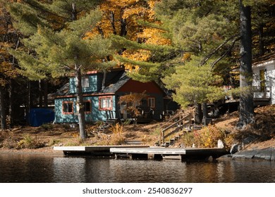 Cozy lakeside cabin surrounded by autumn foliage, reflecting tranquility and nature's beauty. - Powered by Shutterstock