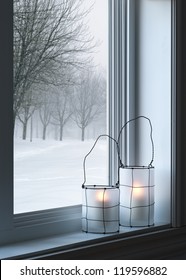 Cozy Lanterns On A Windowsill, With Winter Landscape Seen Through The Window.