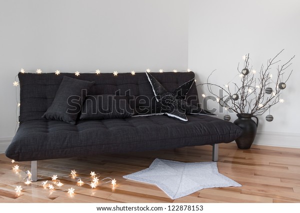 Cozy lights in the living room decorating sofa\
and tree branches.