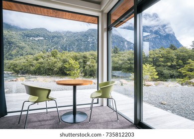 Cozy living room interior design with nature scenic windows view. Green environment lifestyle. Chair and table interior with mountain scenery.  - Powered by Shutterstock