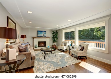 Cozy Living Room Interior With Hardwood Floor And Window View. Furnished With Mocha Colored Sofa, Vintage Lounge Chairs And Round Glass Top Coffee Table On A Rug. Northwest, USA