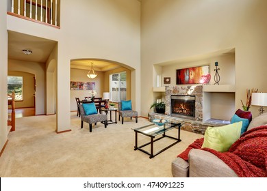 Cozy Luxury Family Room With High Ceiling And Arched Doorway. Stone Fireplace With Niche, Armless Accent Chairs With Geometric Print And Blue Pillows. Northwest, USA