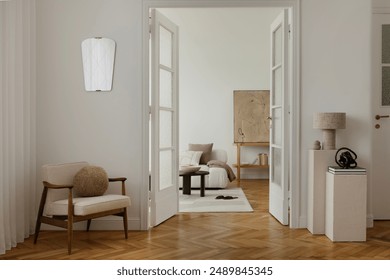 A cozy, minimalist living space with a mid-century modern armchair, soft lighting, and neutral tones. Room features glass doors, textured walls, and elegant decor, creating a serene.