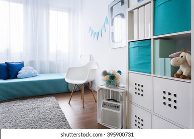Cozy modern room designed for little boy. Grey carpet on wooden floor