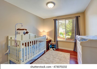 Cozy Nursery Room With A Crib, Carpet And Baby Changing Table. Northwest, USA