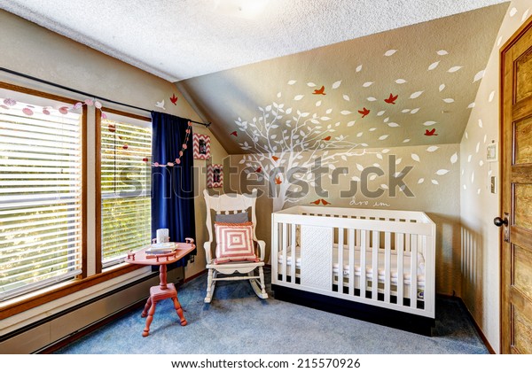 Cozy nursery room with murals, white crib and rocking chair