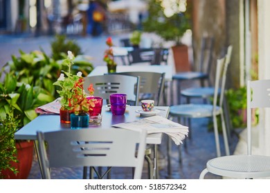 Cozy Outdoor Cafe With Coffee Cup And Newspaper On The Table In Rome, Lazio, Italy