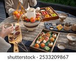 A cozy outdoor table with assorted fresh fruits, vibrant desserts, and rich fondue, evoking a warm and inviting dining experience.