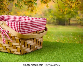 Cozy Picnic Basket On A Green Lawn Against The Backdrop Of Autumn Nature. Romantic Date, Vacation With Friends, Healthy Lifestyle, Delicious Healthy Food. There Are No People In The Photo.