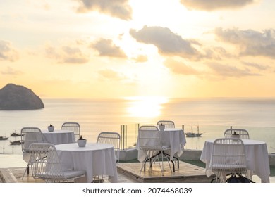 Cozy and romantic cafe with table and chairs on rooftop with sea and sunset view - Powered by Shutterstock