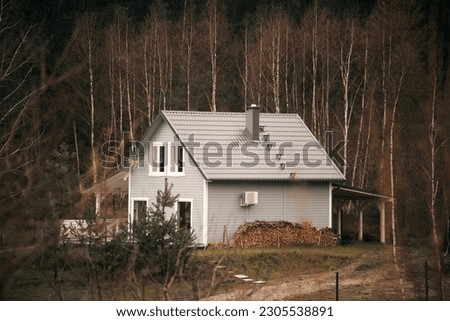 Cozy rural cottage. Forest landscape with small, cozy, rural cottage house far away. Remote house in the countryside.