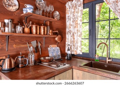 Cozy rustic kitchen interior featuring wooden elements, vintage utensils, and natural decor. A charming blend of wood and modern elements makes it ideal for lifestyle and rural living themes