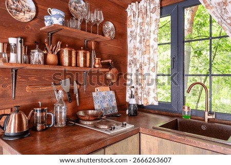 Cozy rustic kitchen interior featuring wooden elements, vintage utensils, and natural decor. A charming blend of wood and modern elements makes it ideal for lifestyle and rural living themes