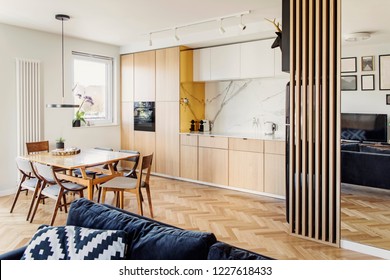 Cozy Scandinavian Open Space With Dining, Living Room And Kitchen With Design Sofa And Family Table. Bright And Sunny Room With Big Windows And Brown Wooden Parquet.	
