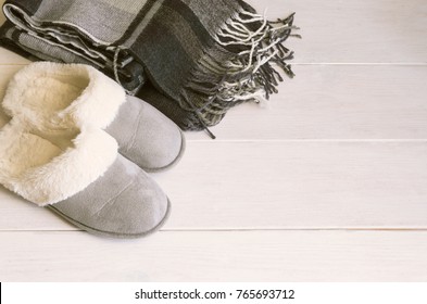 Cozy Slippers And Warm Checkered Blanket On White Wooden Floor. Relax And Stay At Home Concept. Copy Space.