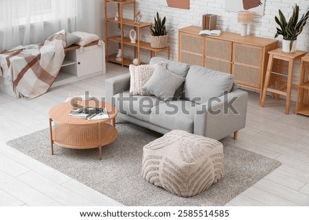 Cozy sofa, sideboard and coffee table in interior of living room