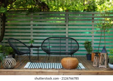 Cozy space in patio or balcony. Interior veranda with Wooden wall and garden furniture. lounge outdoors in summer backyard at house. Spring Terrace with plant, coffee table, comfortable sofa, armchair