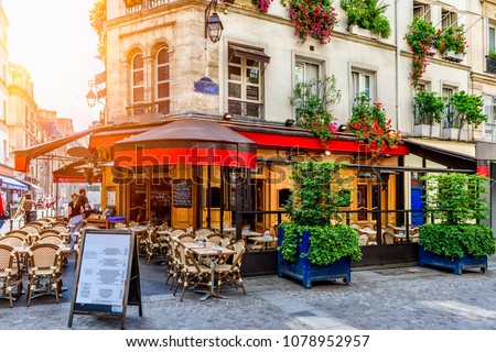 Cozy street with tables of cafe in Paris, France. Architecture and landmark of Paris. Cozy Paris cityscape. 