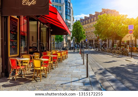 Cozy street with tables of cafe in Paris, France. Cityscape of Paris. Architecture and landmarks of Paris.