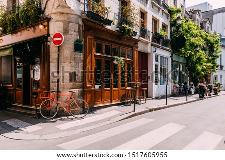 Cozy street with tables of cafe  in Paris, France. Architecture and landmarks of Paris. Postcard of Paris