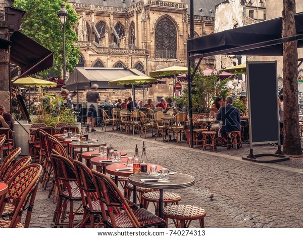 Cozy street with\
tables of cafe in Paris, France. Architecture and landmarks of\
Paris. Postcard of Paris