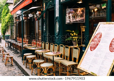 Cozy street with tables of cafe in quarter Montmartre in Paris, France. Architecture and landmarks of Paris. Postcard of Paris