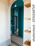 Cozy stylish interior of the house. Arched doorway to the hallway. Contrasting design with white and blue walls and bright yellow accents. Modern built-in wardrobe with mirror