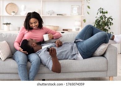 Cozy Time At Home. Romantic African American Couple Relaxing Together On Couch In Living Room, Man Lying On Girlfriend's Knees