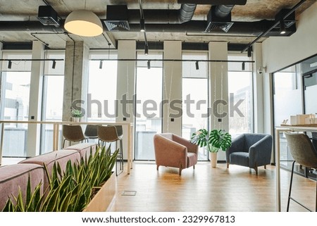 cozy waiting lounge with large windows, soft and comfortable armchairs, green and natural plants in modern coworking environment, workspace organization concept