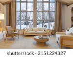cozy warm home interior of a chic country chalet with a huge panoramic window overlooking the winter forest. open plan, wood decoration, warm colors and a family hearth