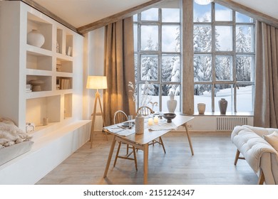 cozy warm home interior of a chic country chalet with a huge panoramic window overlooking the winter forest. open plan, wood decoration, warm colors and a family hearth - Shutterstock ID 2151224347