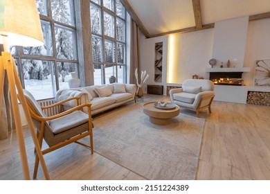 Cozy Warm Home Interior Of A Chic Country Chalet With A Huge Panoramic Window Overlooking The Winter Forest. Open Plan, Wood Decoration, Warm Colors And A Family Hearth