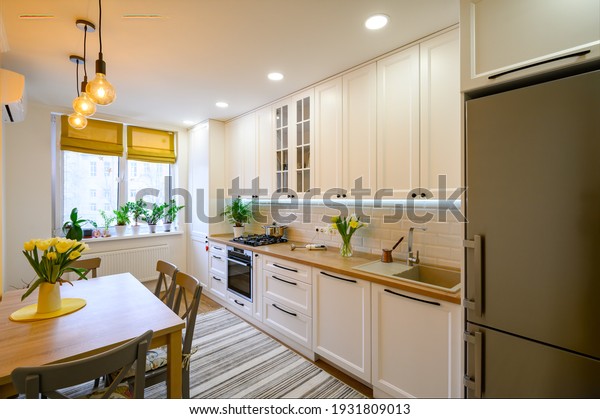cozy well designed modern kitchen interior with\
appliances and dining\
table