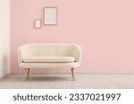 Cozy white sofa and blank frames near pink wall