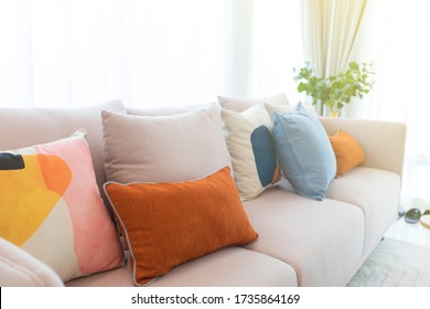 Cozy white sofa with colorful suede pillows in modern living room.