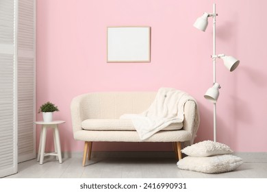 Cozy white sofa, pillows and lamp near pink wall - Powered by Shutterstock - Get 15% off with code: PIKWIZARD15