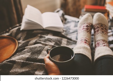 Cozy Winter Day At Home With Cup Of Hot Tea, Book And Warm Socks. Spending Weekend In Bed, Seasonal Holidays And Hygge Concept