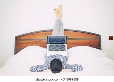 Cozy Young Woman Sitting In Bed With Her Laptop.