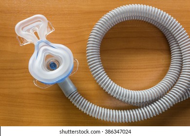 CPAP mask attaching to the air hose , use with CPAP machine to help patients with sleep apnea problem, showing the inside side of the mask, displaying on wooden table