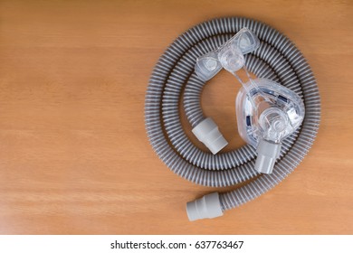 Cpap Mask And Tube On Wooden Table ,top View.
Cpap Components.