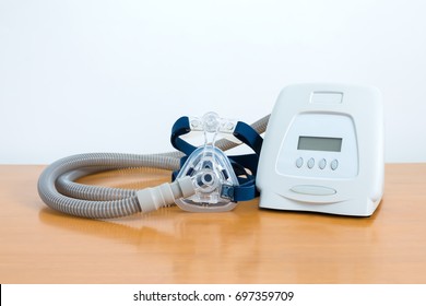 Cpap System Includes Of Cpap Machine,mask,tube And Headgear On Wooden Table,front View White Background.Full Components Of Cpap Machine .
