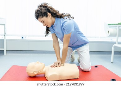 CPR class with instructors talking and demonstrating firt aid, compressions ans reanimation procedure. Cpr dummy - Shutterstock ID 2129831999