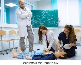 CPR first aid with AED Training Concept. Paramedic demonstrates cardiopulmonary resuscitation on a dummy to medical students and nurses. Emergency services occupation