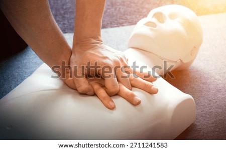 CPR first aid training demonstration - Cardiopulmonary emergency resuscitation medical procedure on dummy. Teaching chest compression technique to students learning via mannequin doll.