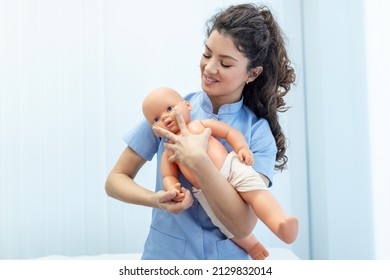 CPR practitioner examining airway passages on infant dummy. Model dummy lays on table and two doctors practice first aid. - Shutterstock ID 2129832014